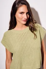 Chaleco de punto color beige con lurex, de corte recto y mangas cortas. Tejido calado con pequeños agujeros.