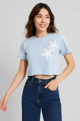 Remera cropped negra de algodón con cuello redondo y estampado de hojas blancas en el hombro.