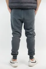 Pantalón de jogging gris topo con puños ajustados, cordón ajustable en la cintura y logo bordado en dorado. Confeccionado en algodón extra suave.