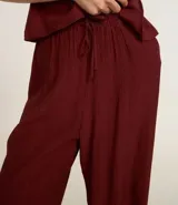 Pantalón recto color borgoña, confeccionado en viscosa texturizada, con lazo en la cintura.