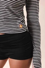 Short deportivo verde oliva de tiro alto, con cintura elástica y logo estampado en la parte trasera.