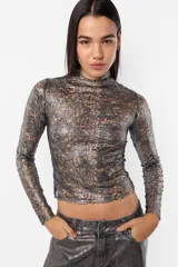 Top manga larga con detalles perforados y acabado foil metálico, semi polera.