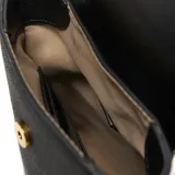 Bandolera pequeña color negro, de material símil cuero con textura, con solapa que cierra con broche metálico dorado. Presenta el logo 'XL' metálico en dorado en la parte frontal inferior. Incluye correa larga regulable y desmontable.