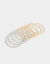 Set de seis pulseras rígidas de metal, tres plateadas y tres doradas.
