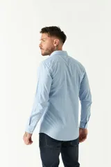 Camisa celeste a cuadros, de corte slim fit, manga larga y logo bordado. Confeccionada en 100% algodón.