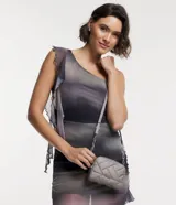 Bolso pequeño color gris con textura capitoneada, correa de cadena y cierre de cremallera.