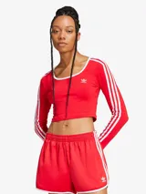 Remera manga larga Adidas, color rojo con las tres tiras blancas en las mangas, corte crop y cuello redondo con ribete blanco.