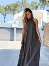 Vestido largo color negro, con escote halter y corte amplio y fluido.