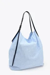 Bolso tipo shopper en tejido con rayas celestes y grises. Asa a contraste de color negro y material sintético con detalles metálicos.