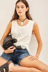 Musculosa blanca de encaje con cuello redondo.