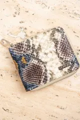 Billetera de cuero vegano con estampado animal print en tonos multicolores, con cierre.