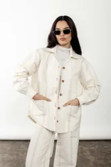 Sobrecamisa de lino y algodón a rayas verticales color crudo, con cuello camisero, cierre frontal con botones y bolsillos de parche en el pecho.