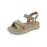 Sandalia de plataforma color beige, con tiras anchas cruzadas en el empeine y tira de ajuste en el tobillo, todas con cierre de velcro. La suela es gruesa y texturizada.