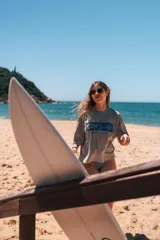 Remerón cropped gris con estampado de motivos playeros en azul y texto "Glassy Waves".