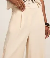Pantalón pantalona de viscosa color crudo, con trabillas en la cintura, pliegues delanteros y bolsillos cargo utilitarios en los laterales.