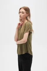 Blusa color crudo de viscosa, corte holgado, con cuello en v y cierre frontal con dos botones de madera.