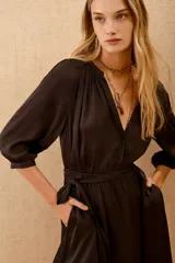 Vestido corto negro con escote en V, mangas 3/4 y lazo en la cintura.