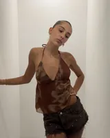 Top halter con escote pronunciado en V y tirantes finos. La prenda es de tejido ligero con un estampado tipo tie-dye o marmolado en tonos marrón y beige. El corte es holgado en la parte inferior.