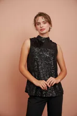 Blusa negra sin mangas con cuello halter y lentejuelas.