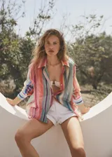 Short de jean blanco de tiro alto con bolsillos laterales y traseros, trabillas y cierre de cremallera con botón.