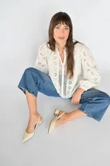Zapato de tiras en color blanco, con tacón bajo y punta fina, confeccionado en cuero suave.