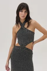 Vestido tejido calado plateado, con escote halter, cut outs en el abdomen y falda larga con tajo lateral.