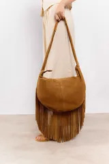 Bolso hobo marrón de gamuza con flecos largos en el contorno inferior y correa de hombro ajustable.