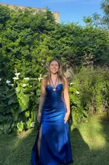 Vestido largo azul brillante con escote halter, argolla en el busto, breteles finos que se atan al cuello, cut-outs bajo el busto y falda con tajo lateral.