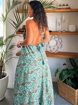 Vestido largo tipo solera, color turquesa con estampado paisley en tonos marrones y dorados. Diseño con escote halter anudado al cuello y abertura frontal central en color liso.