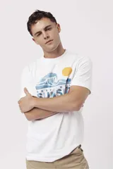 Remera de algodón color naranja claro con cuello redondo y manga corta. Presenta un pequeño estampado gráfico de temática playera en el pecho izquierdo.