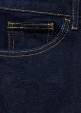 Pantalón de jean azul oscuro de corte recto, tiro medio y largo hasta el tobillo.