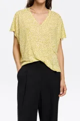 Remera de tejido liviano color amarillo pálido con estampado animal print en tono más oscuro, corte holgado y cuello en V.