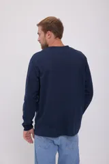 Camiseta azul marino de manga larga y cuello redondo con estampado frontal con la leyenda "Originals Studio BROUGHT TO YOU BY JACK & JONES® DESIGNED IN COPENHAGEN".