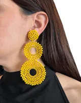 Aros colgantes largos con forma de círculos tramados con cuentas de cristal color turquesa.