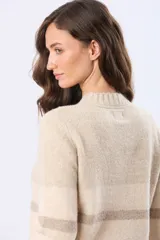 Buzo tejido de tacto suave con diseño de rayas horizontales en blanco, gris claro, gris oscuro y rosado. Presenta cuello redondo y terminaciones acanaladas en puños y dobladillo.