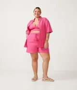 Short de lino color fucsia con cintura elástica y lazo ajustable.