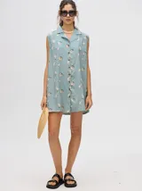Vestido camisero musculosa con cuello camisero, corte recto, largo midi y abotonado al frente. Estampado con motivos marinos.