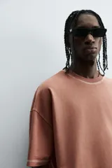 Camiseta color beige de corte holgado, cuello redondo y manga corta.