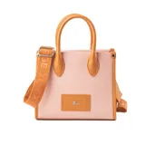 Cartera tote chica color rosa con detalles en marrón, confeccionada en símil cuero graneado. Tiene acceso con cierre, correa regulable y herrajes plateados. Se puede llevar en la mano o como bandolera.