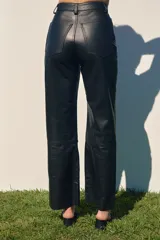 Pantalón de cuero negro, de corte recto y tiro alto, con bolsillos laterales y traseros.