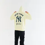 Canguro amarillo claro con capucha, cordones blancos y estampado del logo de los New York Yankees en azul marino.