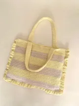 Bolso tipo tote tejido a crochet, con hilo 100% algodón, a rayas horizontales color crema y lila, con volados en los bordes y manijas reforzadas.