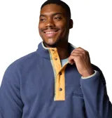 Buzo polar Columbia Helvetia Half Snap para hombre, color azul con detalles en amarillo y bolsillo con cierre en el pecho. Cuenta con cuello alto abotonado y puños elásticos.