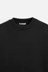 Sudadera negra de corte relaxed fit, confeccionada en tejido interlock de algodón con elasticidad. Tiene cuello redondo, manga corta y bajo acabado en rib.