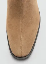 Botín de gamuza color tostado, con diseño de tacón medio y cierre lateral.