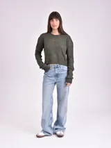 Sweater de punto calado color crudo, de corte holgado y mangas largas.