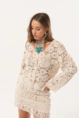 Saco color crudo de crochet con botones y mangas largas.