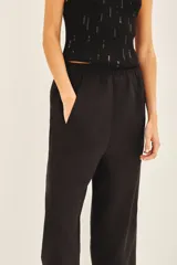 Pantalón babucha color marrón de lino, con cintura elastizada, bolsillos laterales y largo al tobillo.