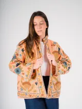 Chaqueta color salmón con bordado floral estilo Suzani en tonos azules, marrones y verdes.