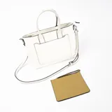 Cartera tipo tote de cuero sintético color blanco con bolsillo externo marrón con cierre. Tiene doble asa de mano y correa larga desmontable y regulable.
